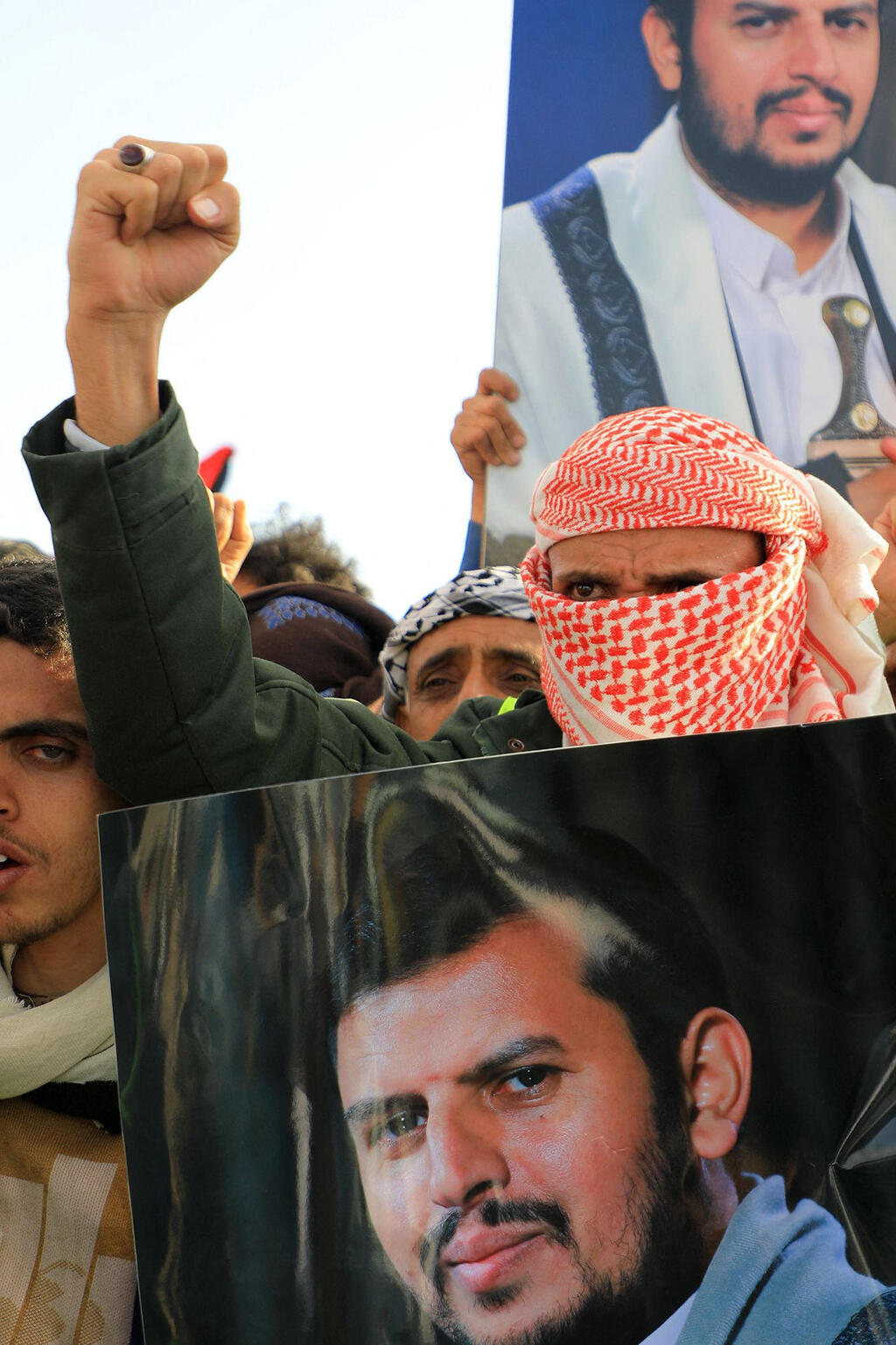 A protester holds up a picture of leader Abdul Malik al-Houthi  