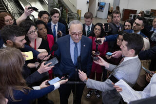 Senate Majority Leader Chuck Schumer (C) speaks to members of the news media before the Senate failed to advance a bipartisan immigration and foreign aid bill