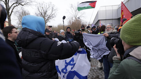 סטודנט מניף את דגל ישראל מול מפגינים פרו-פלסטיניים באוניברסיטה