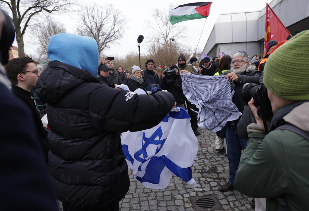 סטודנט מניף את דגל ישראל מול מפגינים פרו-פלסטיניים באוניברסיטה