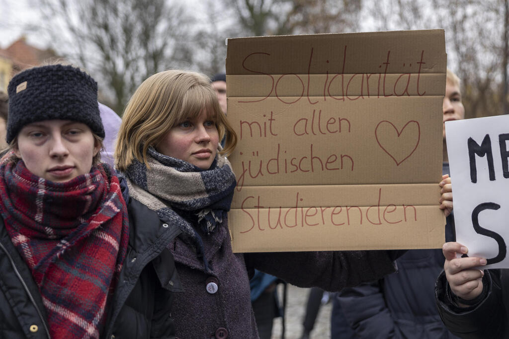 סטודנטית באוניברסיטה בברלין אוחזת בשלט "סולידריות עם הסטודנטים היהודים", אחרי תקיפת להב שפירא