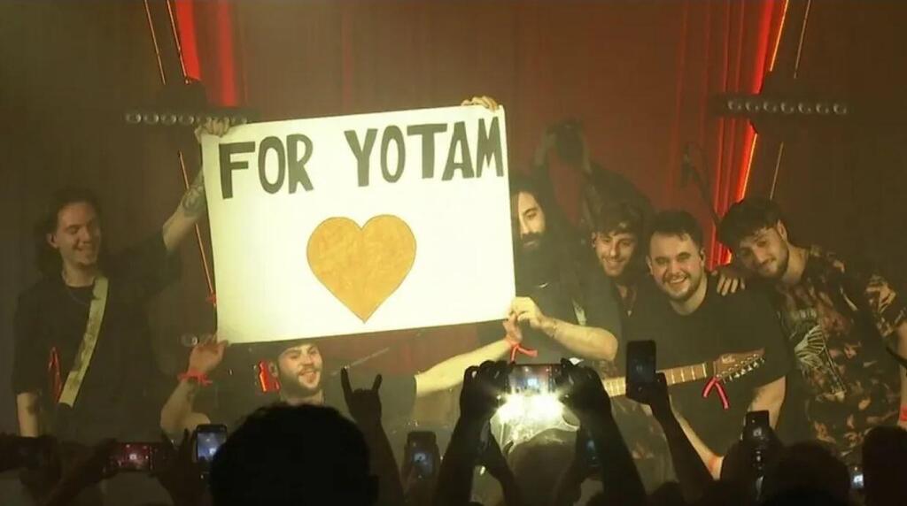 Members of the metal band Persephore hold up a sign in tribute to fallen bandmate Yotam Haim, who was killed in Gaza