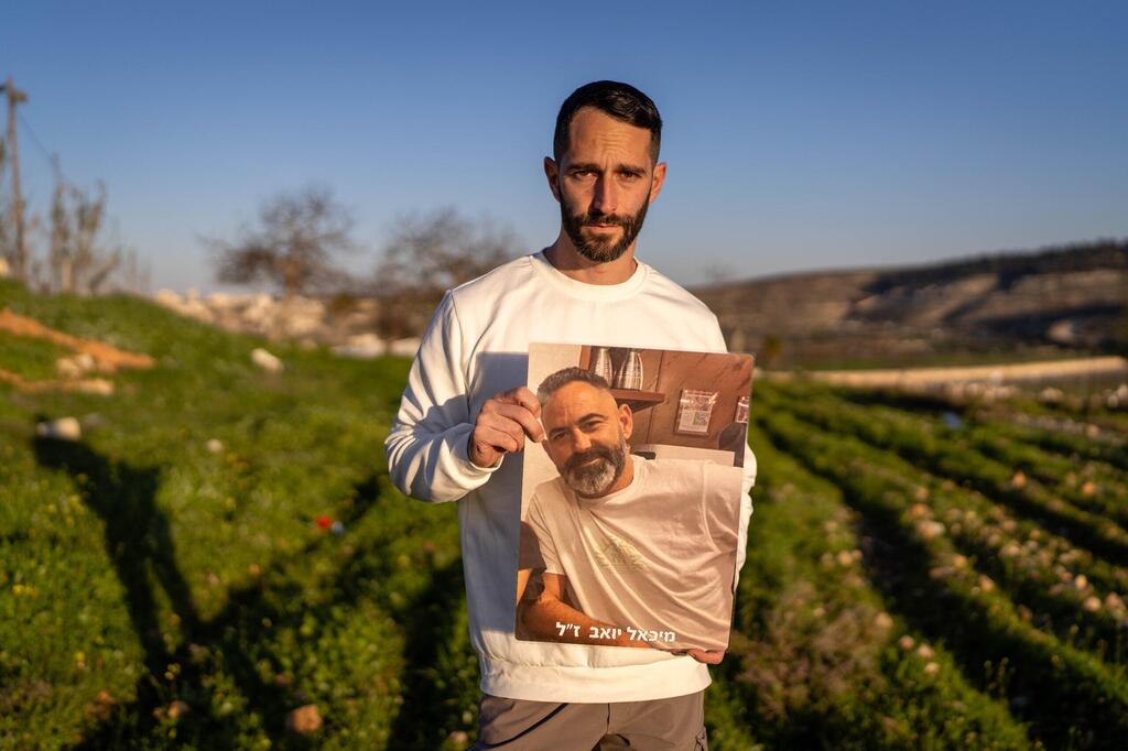 Житель Беэри с портретом похищенного отца (Фото: Шило Шалом) יואב פרחי