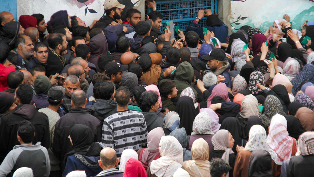 פלסטינים מתקהלים ליד מחסנים של אונר"א ב עזה