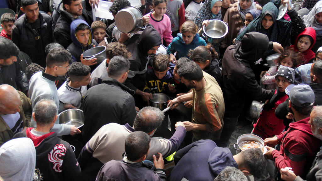 פלסטינים מתאספים לקבל מזון בג'באליה