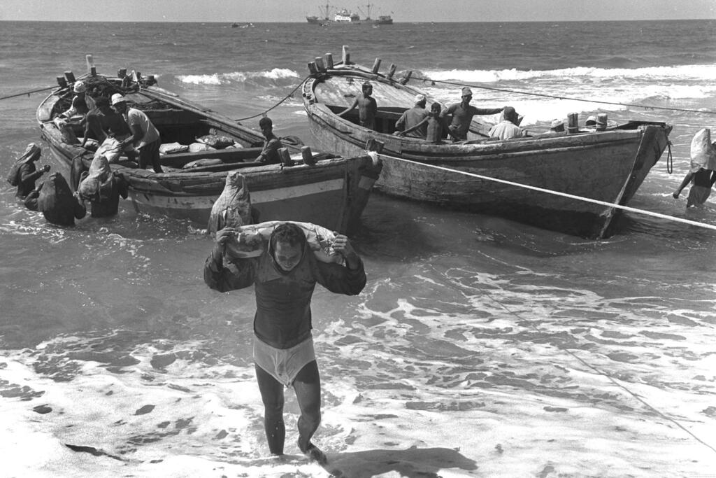 סבל סוחב שקי מלט אל החוף בנמל עזה, 1971