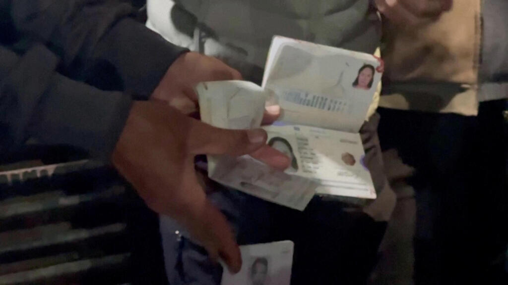 Palestinians show the passport of foreign aid workers killed in an Israeli strike on Gaza 