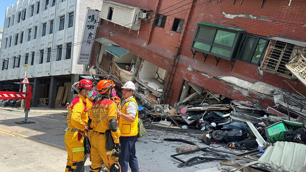 Firefighters work at the site where a building collapsed following the earthquake 