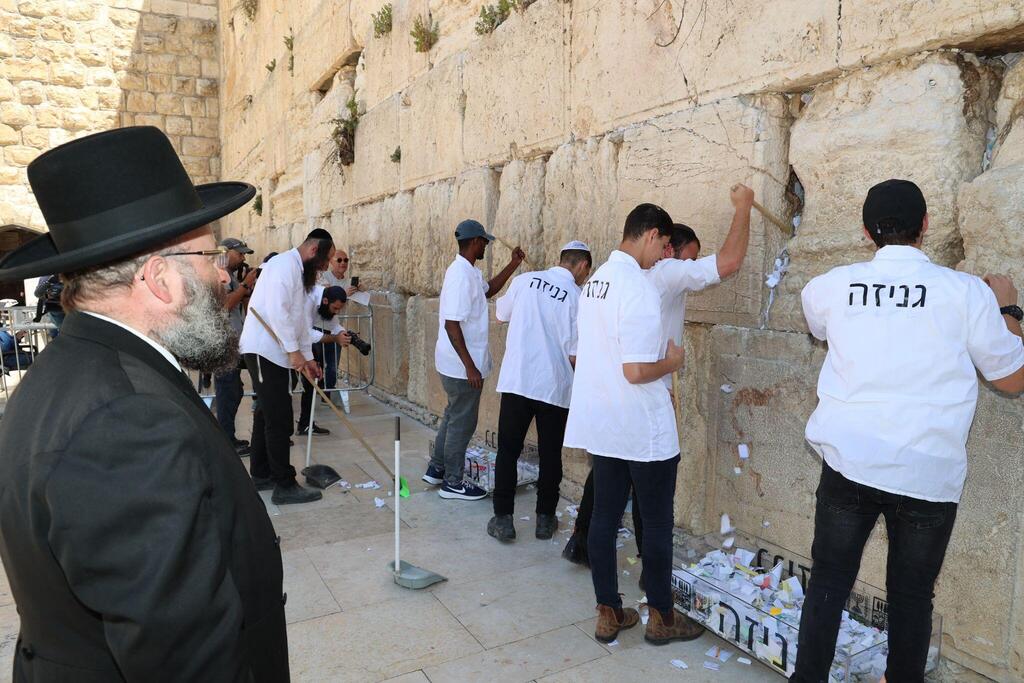 Rabbi Shmuel Rabinowitz, the rabbi of the Western Wall, oversees the clearing of notes from the Western Wall