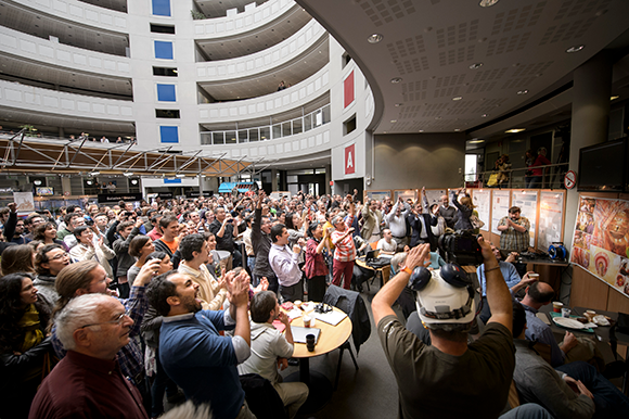 An atmosphere akin to that of a once-in-a-lifetime rock concert. The announcement of the discovery of the Higgs boson in CERN, 2012 (photo: CERN) אווירה של מופע רוק חד-פעמי. אירוע ההכרזה על גילוי בוזון היגס ב-CERN, יולי 2012