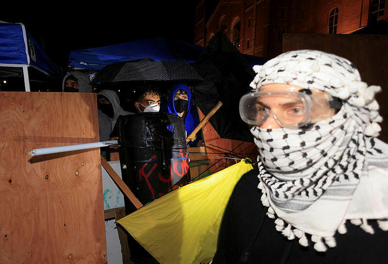 Protesters in support of Palestinians in Gaza stand inside an encampment on the campus of the University of California, Los Angeles (UCLA)on May 1, 2024