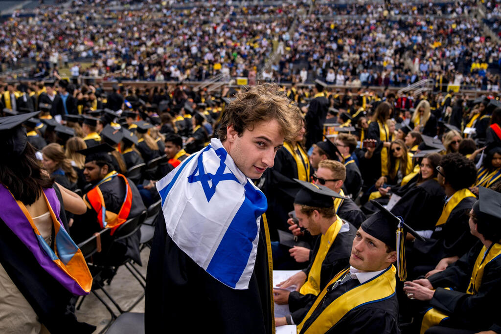 Ari Belchinsky displays the Flag of Israel during the University of Michigan's Spring Commencement ceremony 