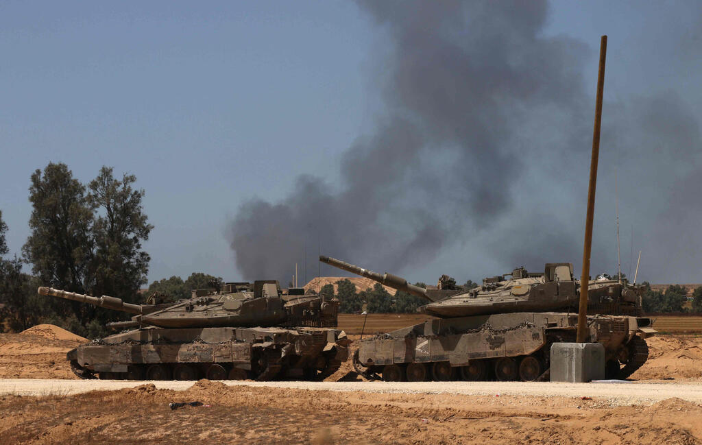 טנקים של צה"ל בדרום ישראל כשברקע עשן בצל תקיפות ברצועת עזה והמבצע ב רפיח