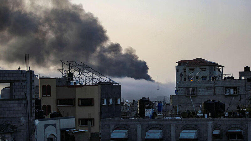 עשן עולה מעל בניין בזריחה, לאחר ההפצצה הישראלית על רפיח בדרום רצועת עזה ב-10 במאי 2024,