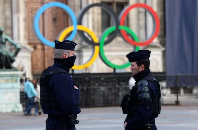 French police officers stand guard near the Olympic rings which are displayed for the Paris 2024 Summer Games in Paris 