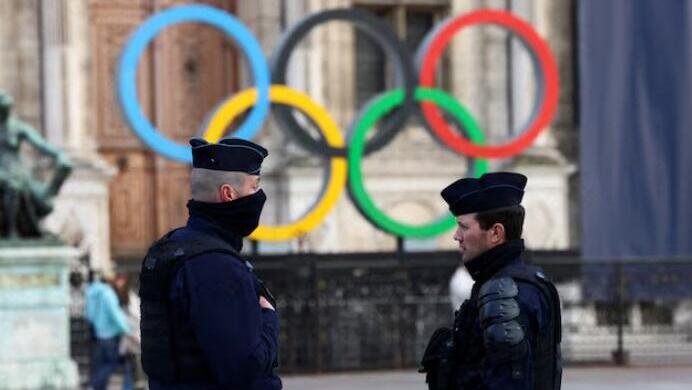 French police officers stand guard near the Olympic rings which are displayed for the Paris 2024 Summer Games in Paris 