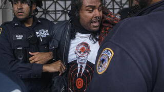 מפגין לובש את החולצה של Comrade Workwear בהפגנה נגד ישראל בניו יורק, מאי 2024