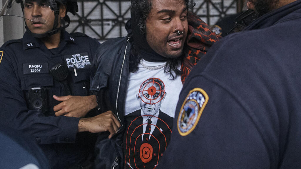 A protester wearing a Comrade Workwear shirt featuring Benjamin Netanyahu as target practice (Photo: Andres Kudacki/AP) מפגין לובש את החולצה של Comrade Workwear בהפגנה נגד ישראל בניו יורק, מאי 2024