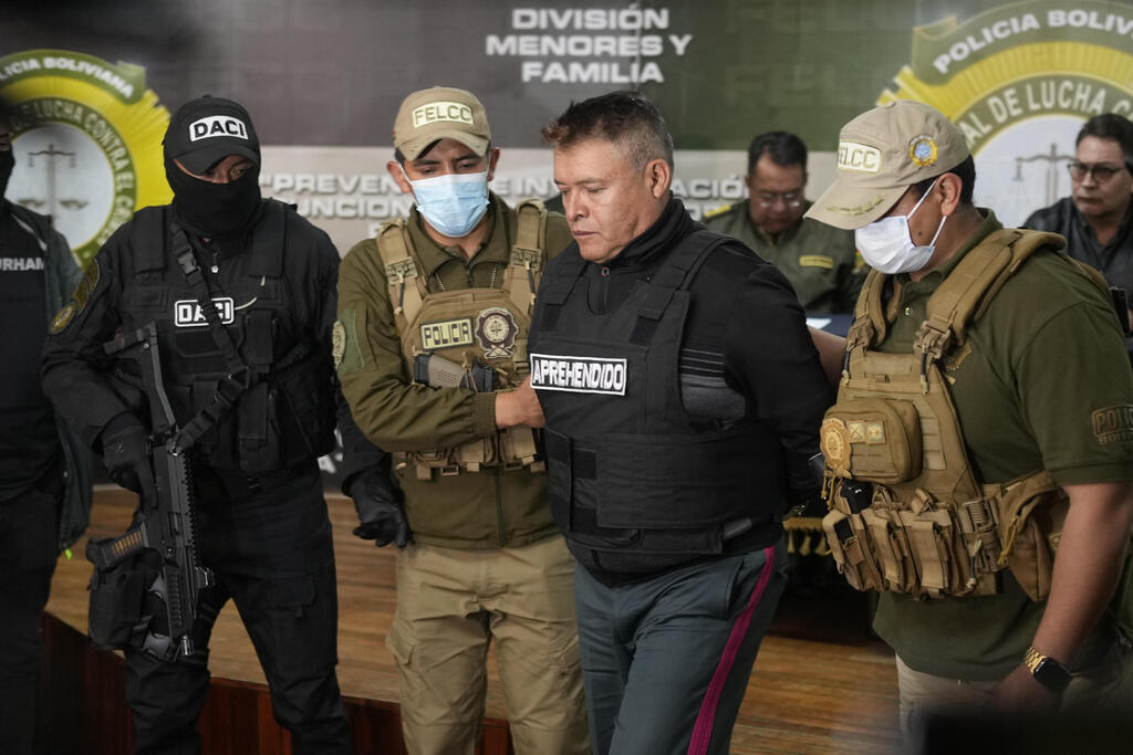 Bolivian police hold the detained Juan Jose Zuniga, former general commander of the Army (Photo: Juan Karita /AP) Bolivian police hold the detained Juan Jose Zuniga, former general commander of the Army