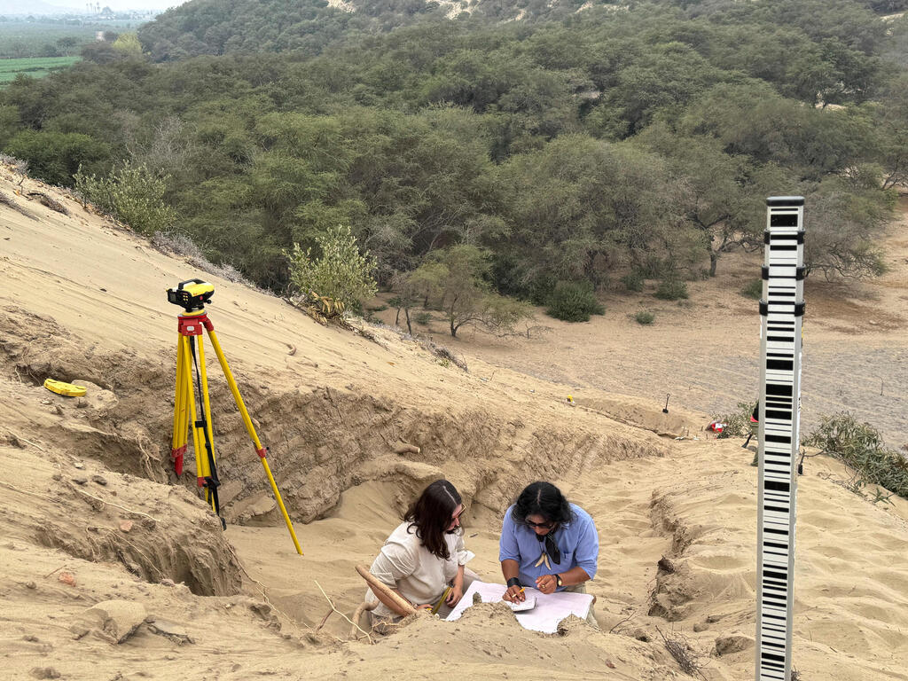 A team of archeologists work on what appear to be parts of a 4,000-year-old ceremonial temple buried in a sand dune of northern Peru, in Lambayeque, Peru