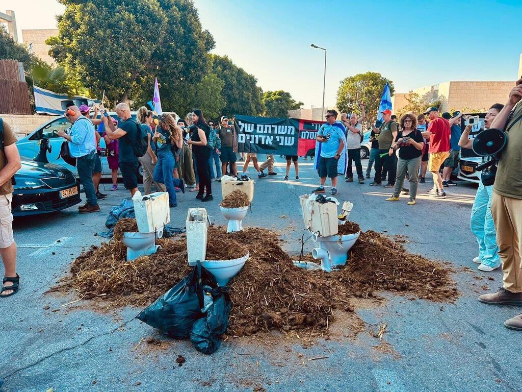 מפגינים מול ביתו של דודי אמסלם, עם אסלות מלאות גללי סוסים