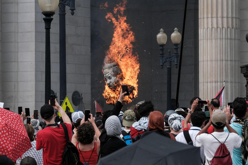 Protestors burn a photo of Benjamin Netanyahu outside of Union Station on July 24, 2024 in Washington, DC