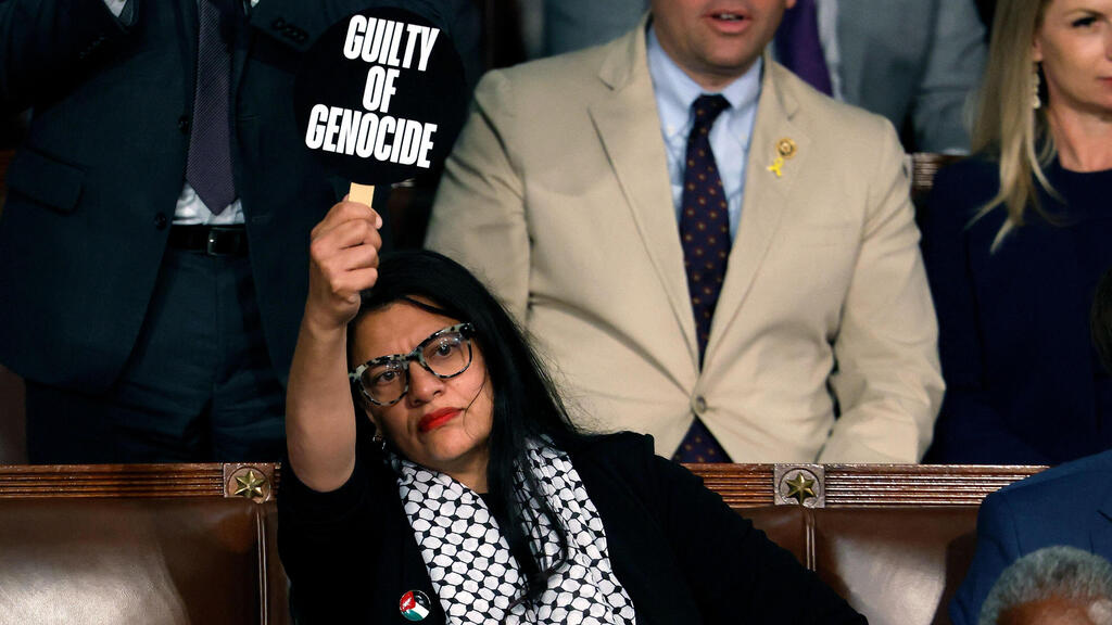 Rashida Tlaib hold up a sign reading "guilty of genocide," during Netanyahu's address to Congress (Photo: Anna Moneymaker / AFP) המחוקקת רשידה טליב עם שלט נגד נתניהו ב נאום ב קונגרס ארה"ב