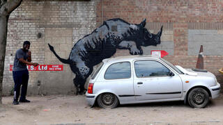 London: People gather around an artwork by street artist Banksy, the eighth to released in eight days