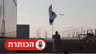 אדם אוחז בדגל ישראל על רקע מטוס ממריא מנמל התעופה בן גוריון