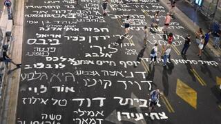  משפחות חטופים כותבות על הכביש את שמות החטופים