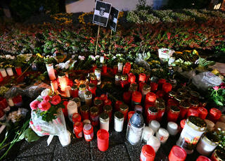 Candles and flowers are pictured near the area where three people were killed and several injured during a knife attack during a city festival in Solingen, Germany