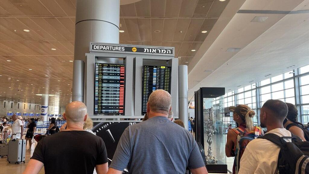 נוסעים מנסים לראות האם טיסתם נדחתה, עקב המתקפה של חיזבאללה