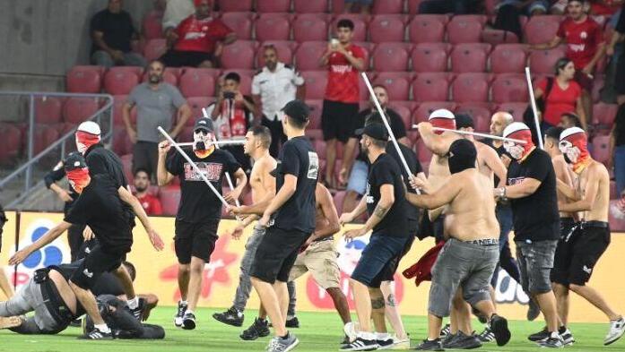 אוהדי הפועל באר-שבע פורצים לכר הדשא כדי להתעמת עם אוהדי סכנין