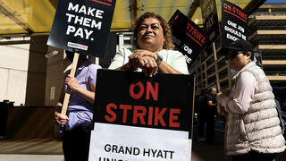 Yesenia Salas stands as hotel workers picket outside the Grand Hyatt hotel Monday