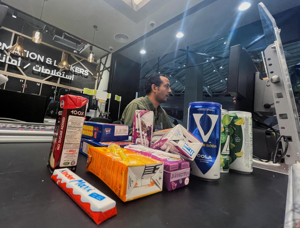 An Egyptian worker sells cans of soda beverages of local brands like V Super Soda Cola and V7