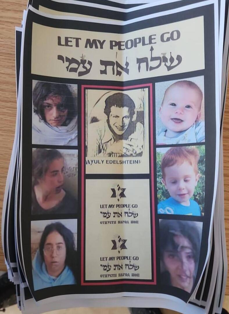 עלונים שחולקו בבית הכנסת ועליהם פני חטופים וחטופות עם הכיתוב "שלח את עמי"