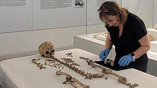 ד"ר מרי לואיס מאוניברסיטת רדינג בודקת את שרידי השלד של "רומיטו 2" שהתגלו בדרום איטליה