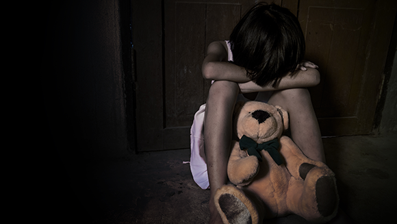 How do childhood traumatic events affect mental health in adulthood? A crying girl sitting on the floor  