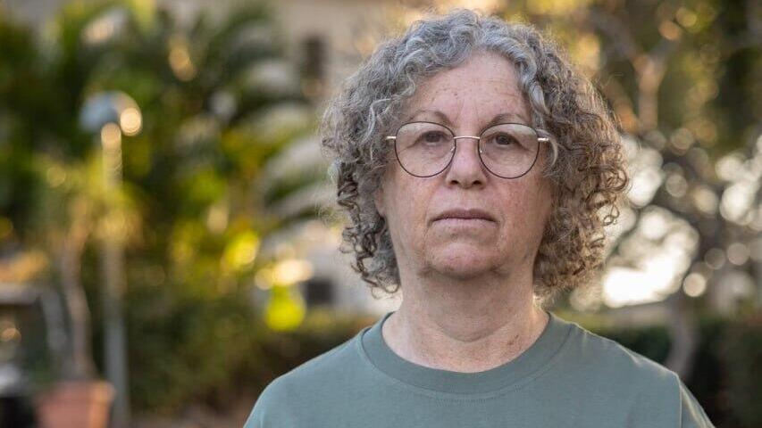 אביבה סיגל ששוחררה מהשבי עם תמונתו של בעלה קית' 