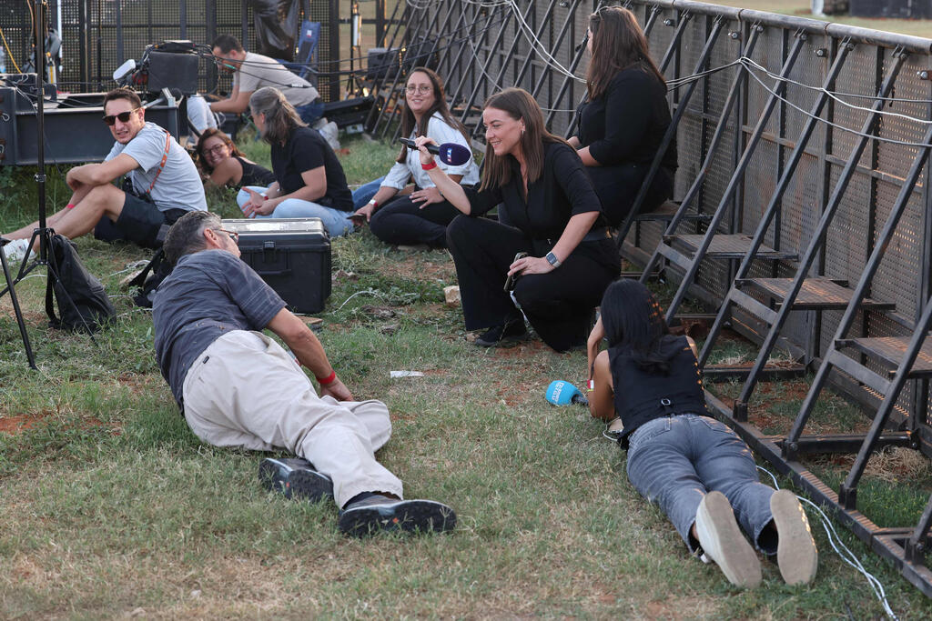 Taking cover in Tel Aviv as rocket sirens wail (Photo: Jack GUEZ / AFP) תל אביב תופסים מחסה בזמן אזעקה