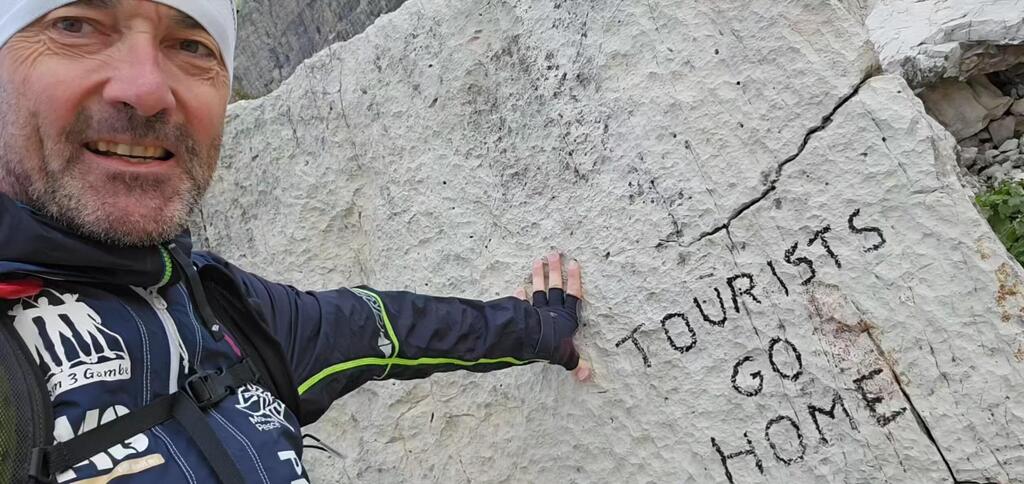The vandalized stone with the writing "tourists go home" 