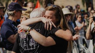 Christian pilgrim comforting elderly survivor of Kibbutz Be'eri massacre 