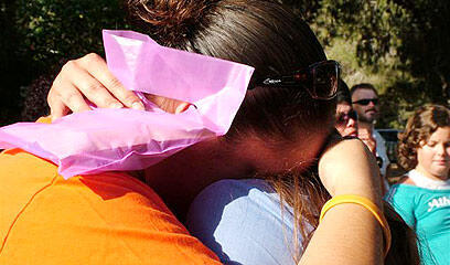 A settler from Kadim weeps as the settlement's flag is lowered for the last time