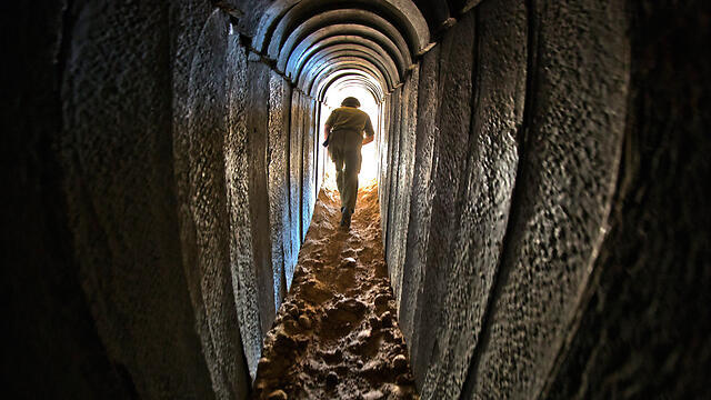 IDF soldier walking through a tunnel uncovered under Israel. (Photo: EPA) (צילום: EPA) IDF soldier walking through a tunnel uncovered under Israel. (Photo: EPA)