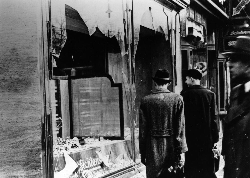 Jewish-owned shops burn during Kristallnacht in 1938 
