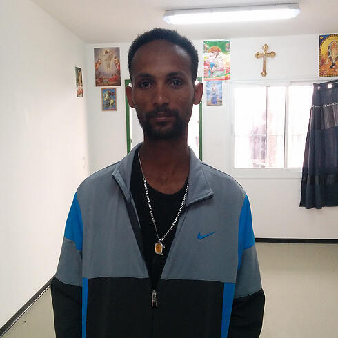 Abrae standing in front of the crosses (Photo: Hotline for Refugees and Migrants)