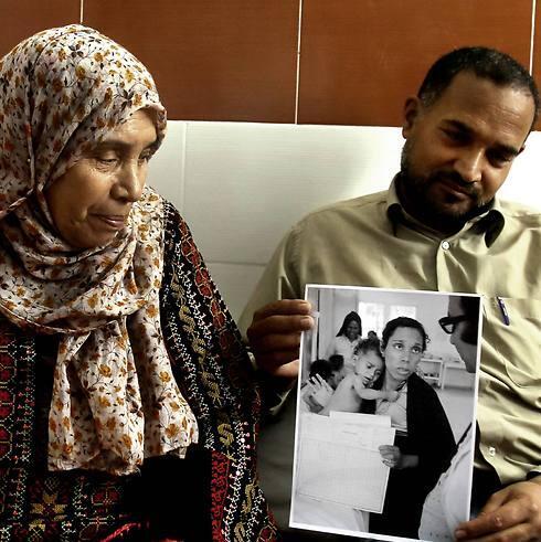 Palestinian refugees Fathiyeh Sattari, 62, and her son Hassan, 40, look at their photograph that was taken at the Rafah UN aid agency clinic in 1975 (Photo: AP)