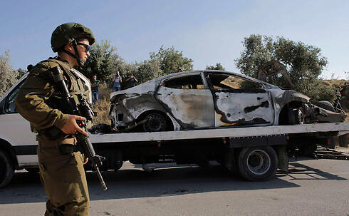 The burned car used in the abduction, found near Dura (Photo: Reuters) (צילום: רויטרס) The burned car used in the abduction, found near Dura (Photo: Reuters)
