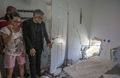 Finance Minister Yair Lapid visiting a home in Sderot that was hit by rocket fire from Gaza. (Photo: AFP)