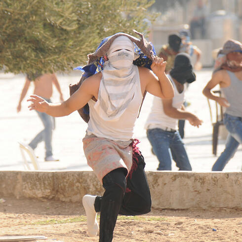 Masked protestors hurl stones at police on Temple Mount on July (Archive photo: Israeli police)